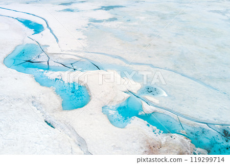 Abstract natural icy background. Texture of ice of the frozen lake. Patterns on the surface of a frozen lake Abstract natural icy background. Texture of ice of the frozen lake. Patterns on the surface of a frozen lake 119299714