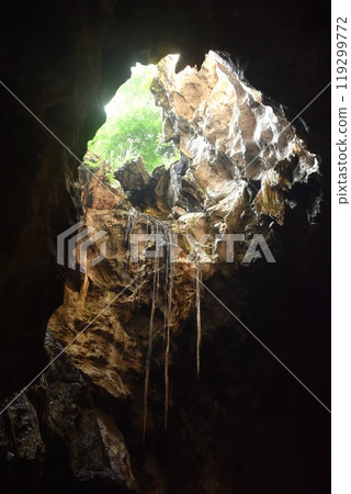stalagmites and stalactites with sunlight through cave hole in Khao Luang cave travel location on Thailand 119299772