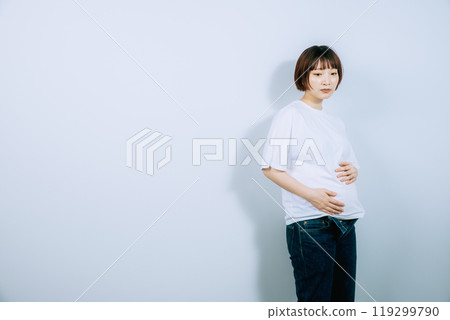 Pregnant woman taking maternity photos in studio 119299790