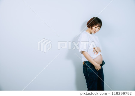 Pregnant woman taking maternity photos in studio Pregnant woman taking maternity photos in studio 119299792