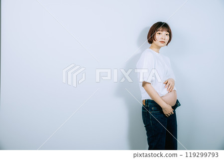 Pregnant woman taking maternity photos in studio Pregnant woman taking maternity photos in studio 119299793