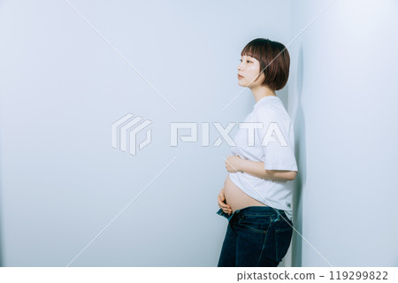 Pregnant woman taking maternity photos in studio 119299822
