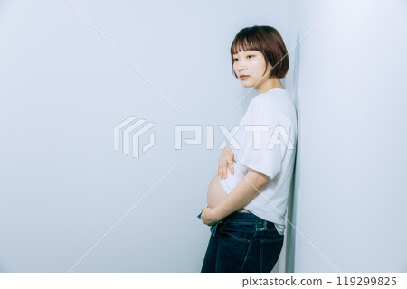 Pregnant woman taking maternity photos in studio 119299825