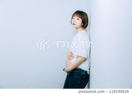 Pregnant woman taking maternity photos in studio 119299826