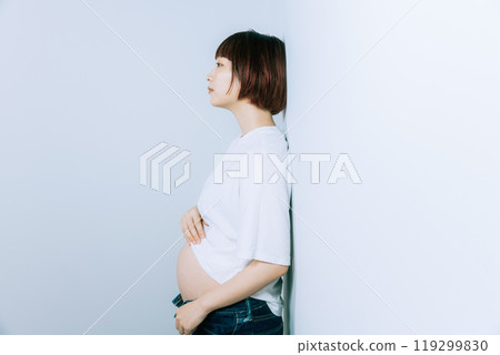 Pregnant woman taking maternity photos in studio Pregnant woman taking maternity photos in studio 119299830