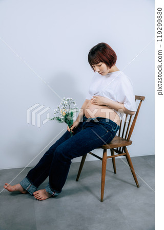 Pregnant woman taking maternity photos in studio 119299880