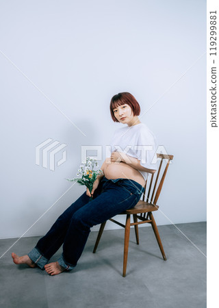 Pregnant woman taking maternity photos in studio 119299881