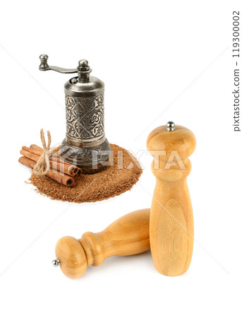 Hand-held spice grinder, sticks and cinnamon powder isolated on white background. Free space for text. Collage. Hand-held spice grinder, sticks and cinnamon powder isolated on white background. Free space for text. Collage. 119300002