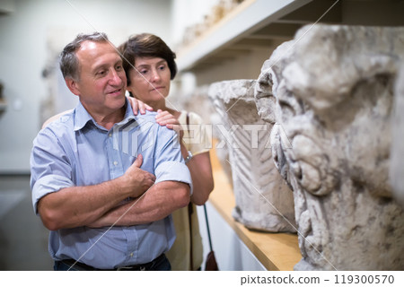 Mature men and women collector evaluates the exhibition in museum 119300570