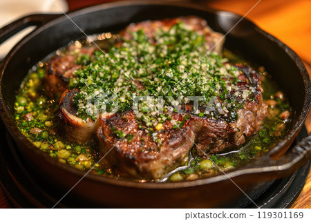 Traditional braised Italian ossobuco alla Milanese served in a cast-iron design stewpot 119301169