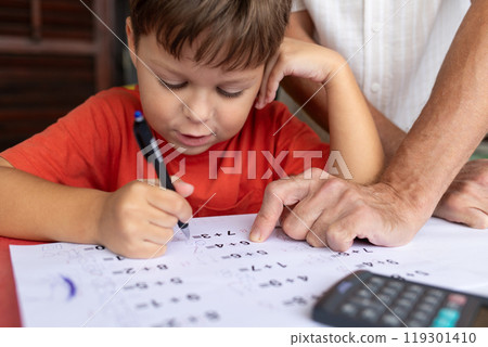 A six-year-old boy with dysgraphia and dyscalculia works on his math homework. 119301410