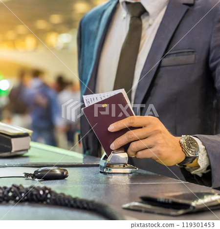 A man going through immigration procedures at the airport counter 119301453