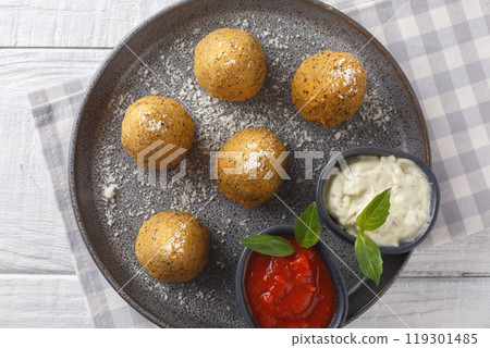 Homemade Deep Fried Risotto Arancini served with two sauces close-up in a plate. Horizontal top view 119301485