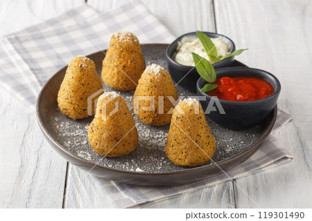 Balls of rice also called arancini served with two sauces close-up in a plate. Horizontal 119301490