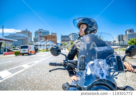 A female rider touring Yokohama on a cruiser bike 119301772
