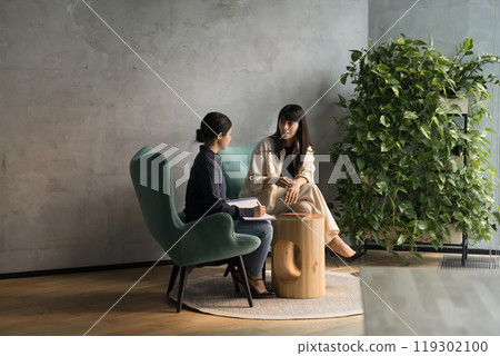Busy diverse business women talking in office lounge zone Busy diverse business women talking in office lounge zone 119302100