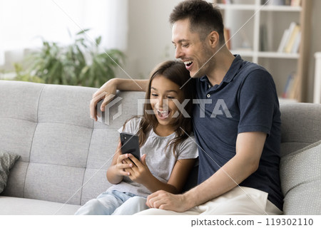 Excited millennial father little daughter read prize message on smartphone 119302110