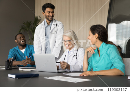 Multicultural doctors teammates listen to leader analyzing case using laptop 119302137
