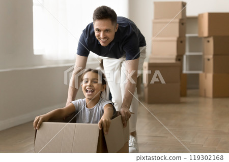 Excited dad house buyer playing with daughter riding in box 119302168