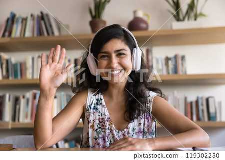 Happy young Indian influencer woman wearing headphones, broadcasting online 119302280