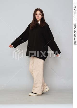Teen model poses in a plain black hoodie, ready for logos. A versatile mockup for your creative design printing. Teen model poses in a plain black hoodie, ready for logos. A versatile mockup for your creative design printing. 119302379