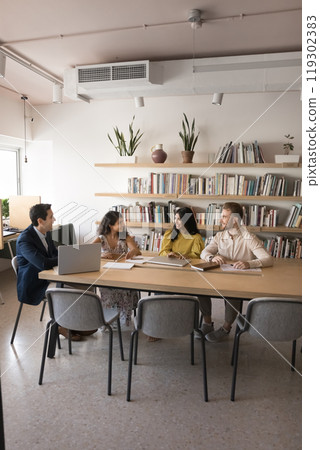 Positive coworkers brainstorming on project in office meeting space 119302383