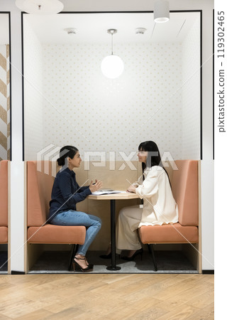 Multiethnic business colleagues sitting at table in office separate booth Multiethnic business colleagues sitting at table in office separate booth 119302465