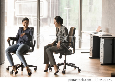 Happy excited multiethnic managers women laughing out loud Happy excited multiethnic managers women laughing out loud 119302469