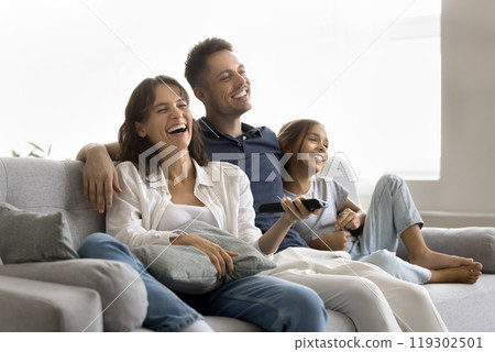 Relaxed family young spouses tween daughter watch television on couch 119302501