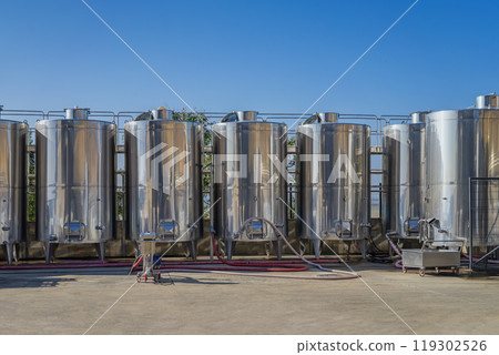 Industrial winemaking equipment with multiple tanks outside in open air 119302526