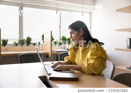 Serious young Indian project manager woman working at computer 119302562