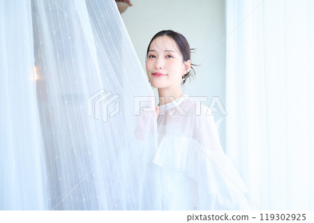 一個被蕾絲窗簾包圍的女人 119302925
