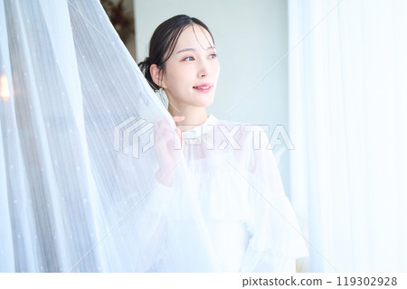 一個被蕾絲窗簾包圍的女人 119302928
