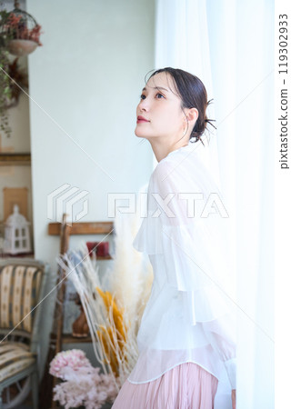 A woman surrounded by lace curtains A woman surrounded by lace curtains 119302933