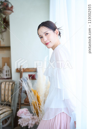 A woman surrounded by lace curtains A woman surrounded by lace curtains 119302935