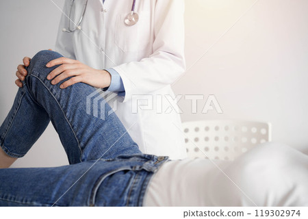 Doctor and patient are at the medical inspection in clinic. Orthopedic examines the knee of a young woman. Medicine concept Doctor and patient are at the medical inspection in clinic. Orthopedic examines the knee of a young woman. Medicine concept 119302974