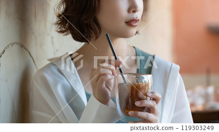 A woman drinking at a cafe 119303249