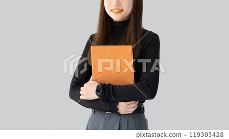 Smiling woman/businesswoman holding a binder 119303428