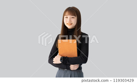 Smiling woman/businesswoman holding a binder Smiling woman/businesswoman holding a binder 119303429