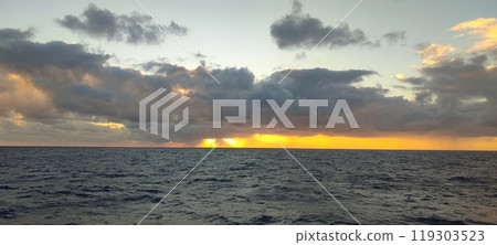 A vast expanse of water accompanied by a cloudy sky overhead A vast expanse of water accompanied by a cloudy sky overhead 119303523