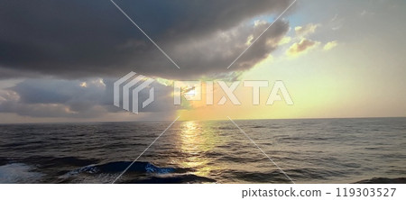 A vast expanse of water accompanied by a cloudy sky overhead A vast expanse of water accompanied by a cloudy sky overhead 119303527