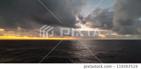 A vast expanse of water accompanied by a cloudy sky overhead A vast expanse of water accompanied by a cloudy sky overhead 119303528