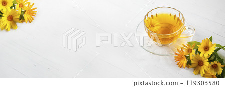 Banner with calendula tea glass cup and fresh marigold flowers. Copy space. Wooden background. Banner with calendula tea glass cup and fresh marigold flowers. Copy space. Wooden background. 119303580