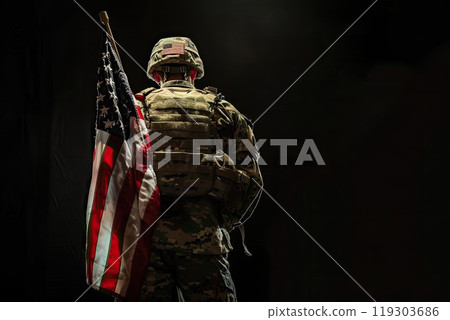 In this image, a soldier proudly carries an American flag on his back 119303686