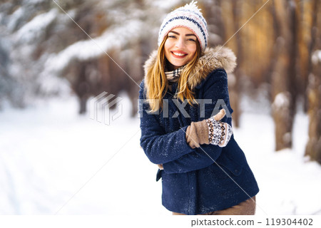 Portrait of beautiful girl with long hair, in a blue jacket. Fashion young woman in winter forest. Portrait of beautiful girl with long hair, in a blue jacket. Fashion young woman in winter forest. 119304402