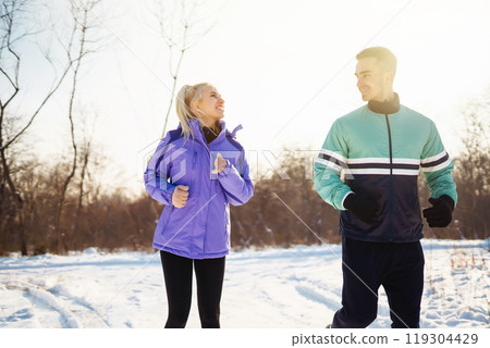 Young couple winter morning exercise at snowy forest. Healthy fitness lifestyle. Sport, Active life. Young couple winter morning exercise at snowy forest. Healthy fitness lifestyle. Sport, Active life. 119304429