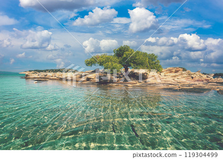 Seascape on a sunny day. Quiet bay with a small rocky island and sandy beach. beautiful lagoon. Lagonisi beach, Halkidiki, Greece 119304499