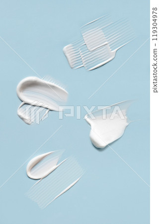 Smears of cream on a blue background. 119304978