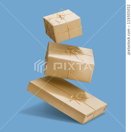 Presens wrapped in craft paper falling on blue background Presens wrapped in craft paper falling on blue background 119305052