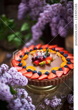 Delicious homemade chocolate tart decorated with fresh strawberry, blueberry, apricot and cherry Delicious homemade chocolate tart decorated with fresh strawberry, blueberry, apricot and cherry 119305166